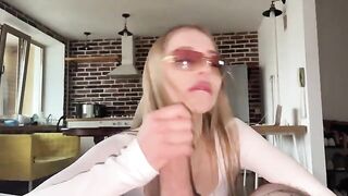 A pretty woman with glasses gets her face covered with a cumshot