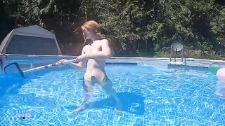 Redhead in red bikini diving in the swimming pool