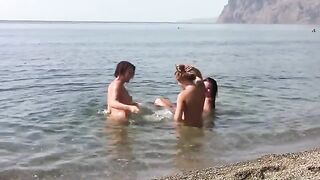 Three nudist girls on the beach with erogenous zones exposed