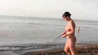 A naked beauty plays on the beach with a great body