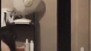 A guy admires himself in the mirror, completely naked and huge cock