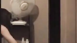 A guy admires himself in the mirror, completely naked and huge cock