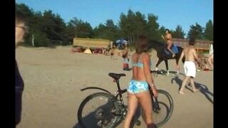 A topless beauty is having fun on the sandy beach, showcasing her charm