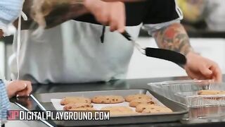 A petite individual, Khloe Kapri, bakes cookies in a revealing apron, showcasing her slim 5'3" frame and trimmed style